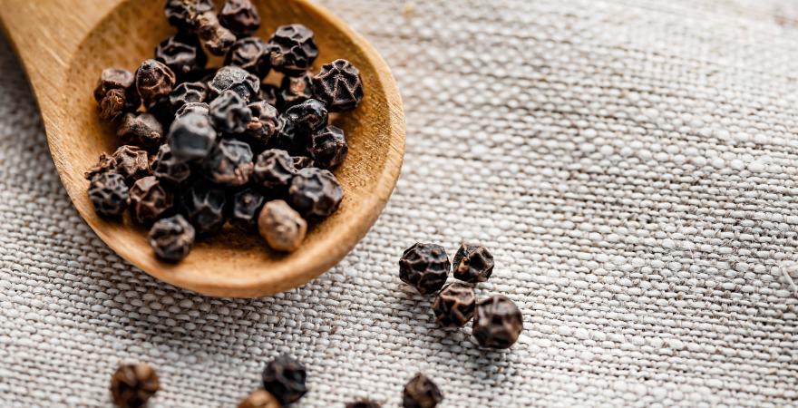 Black pepper on a wooden spoon