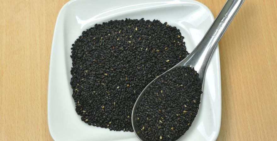 black sesame seeds on a spoon and plate