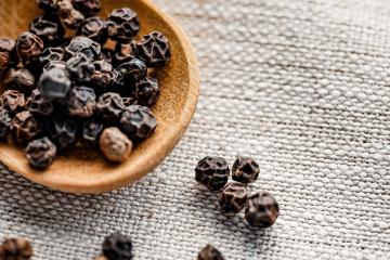 Black pepper on a wooden spoon